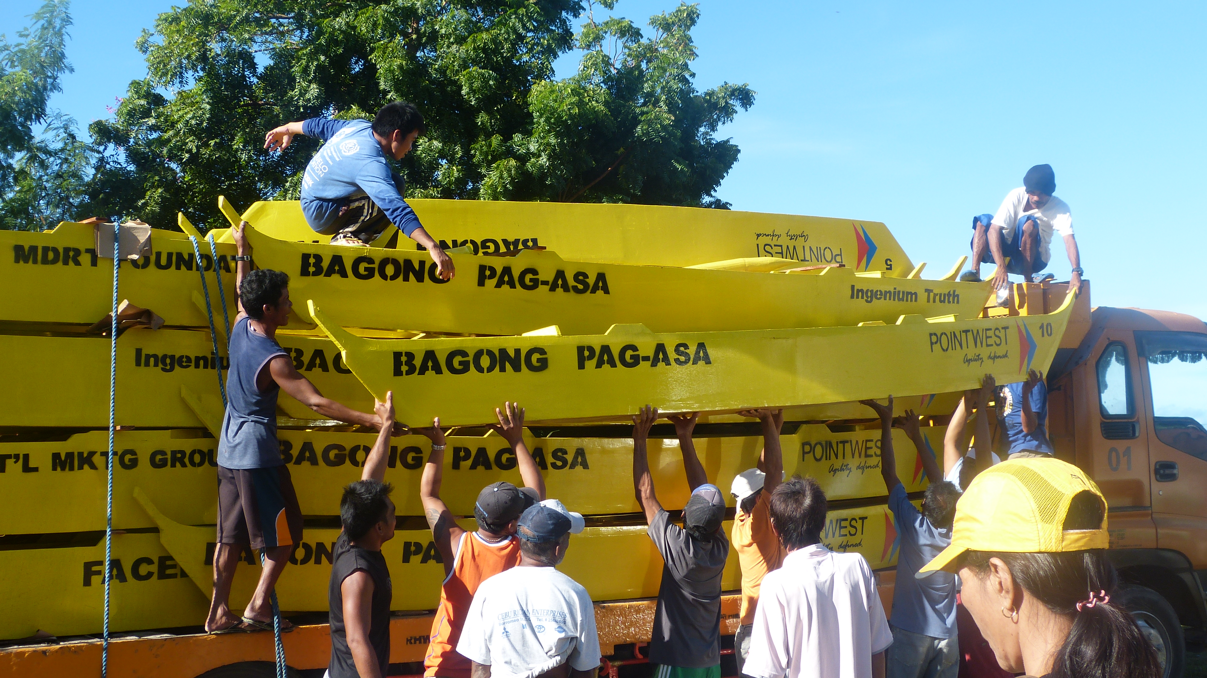 San Remigio men carefully unloading the boats that were manufactured from Talisay City.